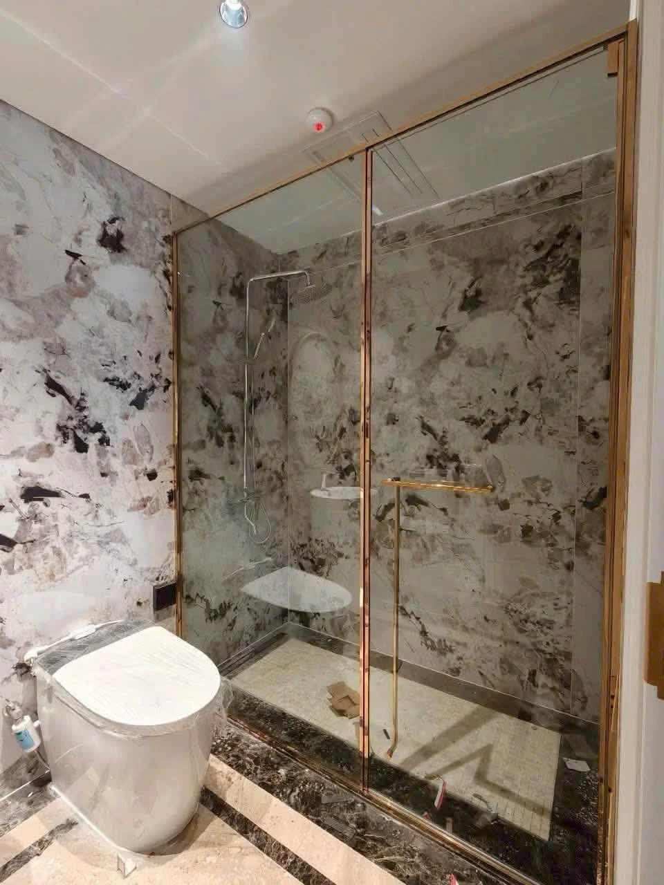 Cabin kính trong phòng tắm đá sáng màu