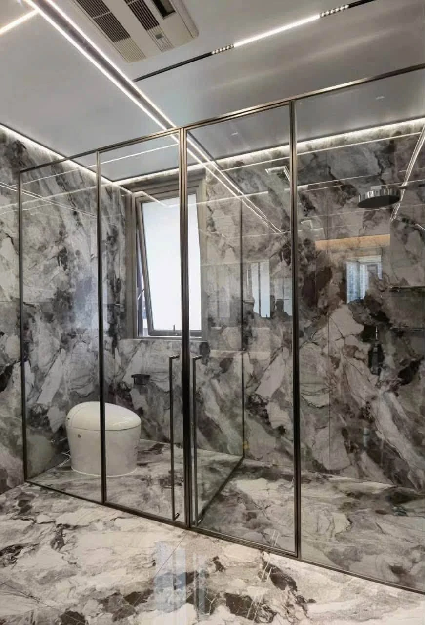 Vách kính và cửa cabin trong phòng tắm ốp đá xám